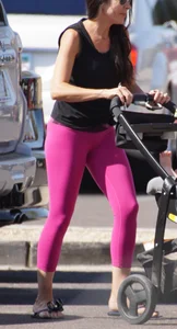 Milf brunette in purplish-pink leggings looking sexy in the parking lot