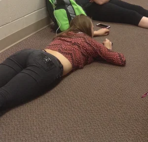 College teen in tight jeans laying on the floor