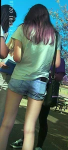 Skinny girl with purple hair in denim shorts