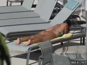 Hot milf sunbathing in a thong by pool and swimming