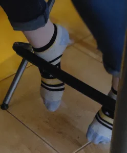 Under Table Closeup of a Teen Girl's Feet in Socks With Shoes Taken Off
