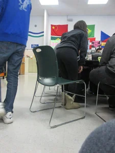 Candid Girl in Leggings Bending Over Desk in College Classroom
