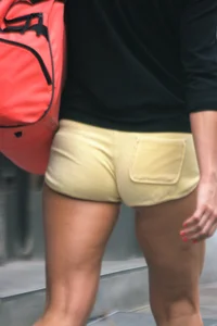 Blonde looking sexy walking in short yellow shorts