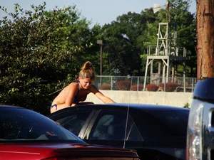 Group of cute girls at a car wash in bikinis and shorts