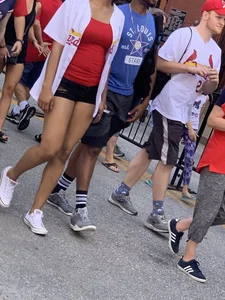 Bunch of girls in various outfits at a Cardinals baseball game