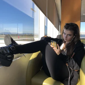 Teen Girl in Leggings and Boots Sitting With Legs on the Windowsill