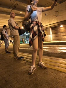 Cute Teen in Shorts on the Tram Stop