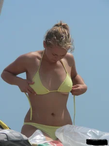 Sexy blonde on the beach in a yellow thong bikini