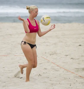 Hot girls playing beach volleyball in bikinis and shorts