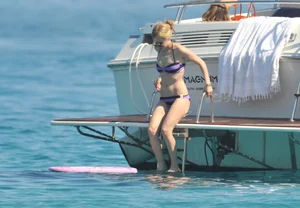 Avril Lavinge looking sexy in purple bikini on a boat