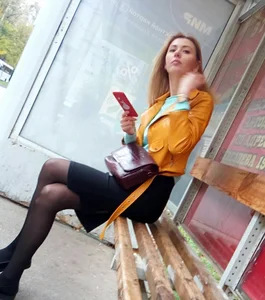 Skinny Tall Girl Sitting in the Bus Stop with Crossed Legs in Black Pantyhose