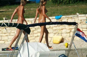 Two sexy nude beach friends getting some sun