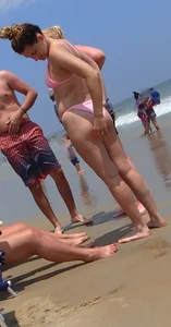 Sexy girl on the beach in a pink bikini