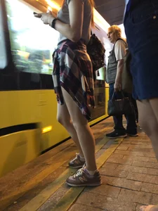 Cute Teen in Shorts on the Tram Stop