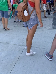 Bunch of girls in various outfits at a Cardinals baseball game