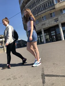 Cute Girl in a Short Denim Skirt Walking on a Street And Waiting on a Crosswalk Gallery