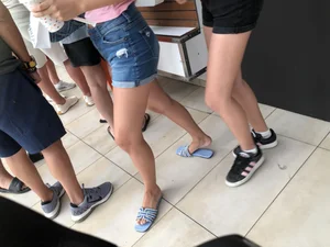 Two skinny teens in shorts at food court, nice skinny legs
