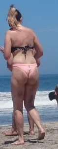 Chunky beach blonde babe in a pink thong bikini