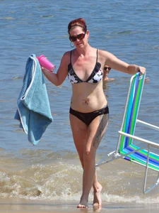Tattooed redhead milf in a bikini at the beach