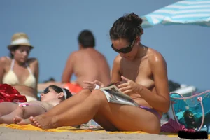 2 topless girls at the beach in thongs