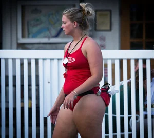 Thick blonde lifeguard in red swimsuit