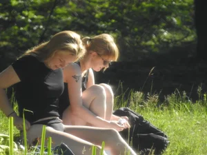 Two sexy friends in black bikinis laying out