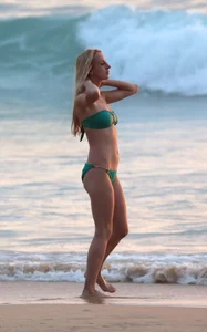 Sexy brunette in thong bikini and blonde friend in green bikini at the beach