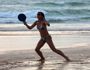 Older lady playing on the beach in her bikini