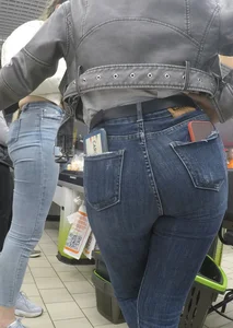 Two hot milfs in tight blue jeans standing at the cash register at the supermarket, awesome big butts