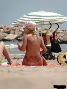 Tattooed blonde with big tits topless and in thong