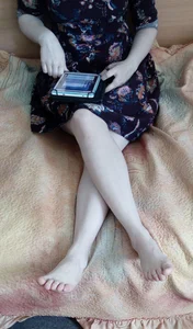 Barefoot Girl in a Dress Sitting With Crossed Legs in Bed Home Photo