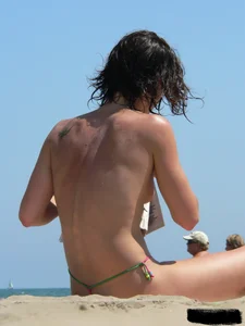 Topless beach milf looking sexy in a tiny g-string bikini