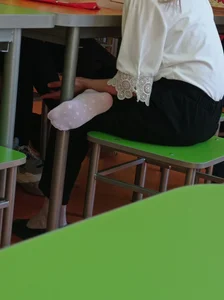 Teen student's foot in a white sock in class
