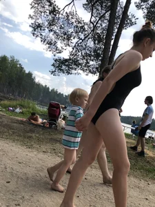 Cute Barefoot Girl in a Black Body Swimsuit Walking on a Road