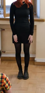 Young Ginger Girl in a Dress And Black Pantyhose Touching Her Hips