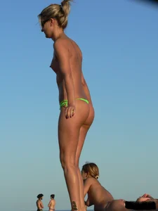 Bunch of sexy babes on the beach topless and in thong bikinis