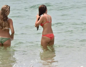Two sexy ass girls on the beach in bikinis