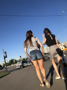 Two Hot Girls on a Street in Denim Shorts and a Skirt - One Touching Her Booty - Creepshots Gallery