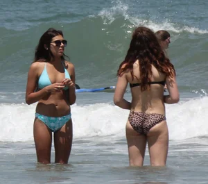 Brunette and redhead on the beach in bikinis looking sexy