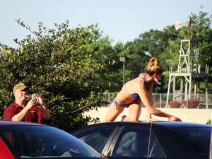Group of cute girls at a car wash in bikinis and shorts