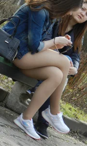 Girl in Pantyhose Sitting Cross-Legged on the Park Bench Candid