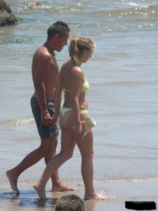 Sexy blonde on the beach in a yellow thong bikini