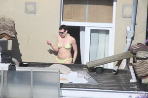 Neighbor on rooftop tanning in bikinis