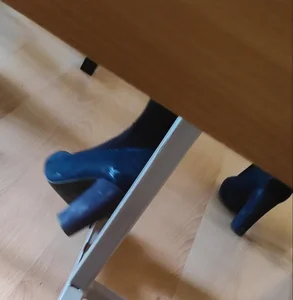 Closeup of a College Teen Girl's Feet in High Heeled Shoes Under Desk
