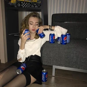 Girl who Likes Pepsi a Lot Sitting on the Floor in a Skirt and Stockings