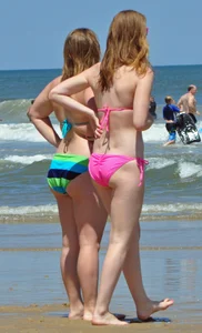 Two beach friends in bikinis one with back dimples and the other thick