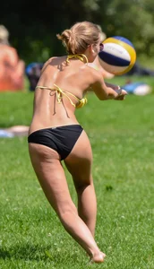 Sexy blonde girl in the park playing volleyball in her skimpy bikini