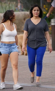 Sexy dog walker in shorts and tank top with friend in blue jeans