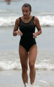 Skinny sexy lady on the beach in a black swimsuit