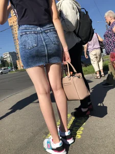 Cute Girl in a Short Denim Skirt Walking on a Street And Waiting on a Crosswalk Gallery